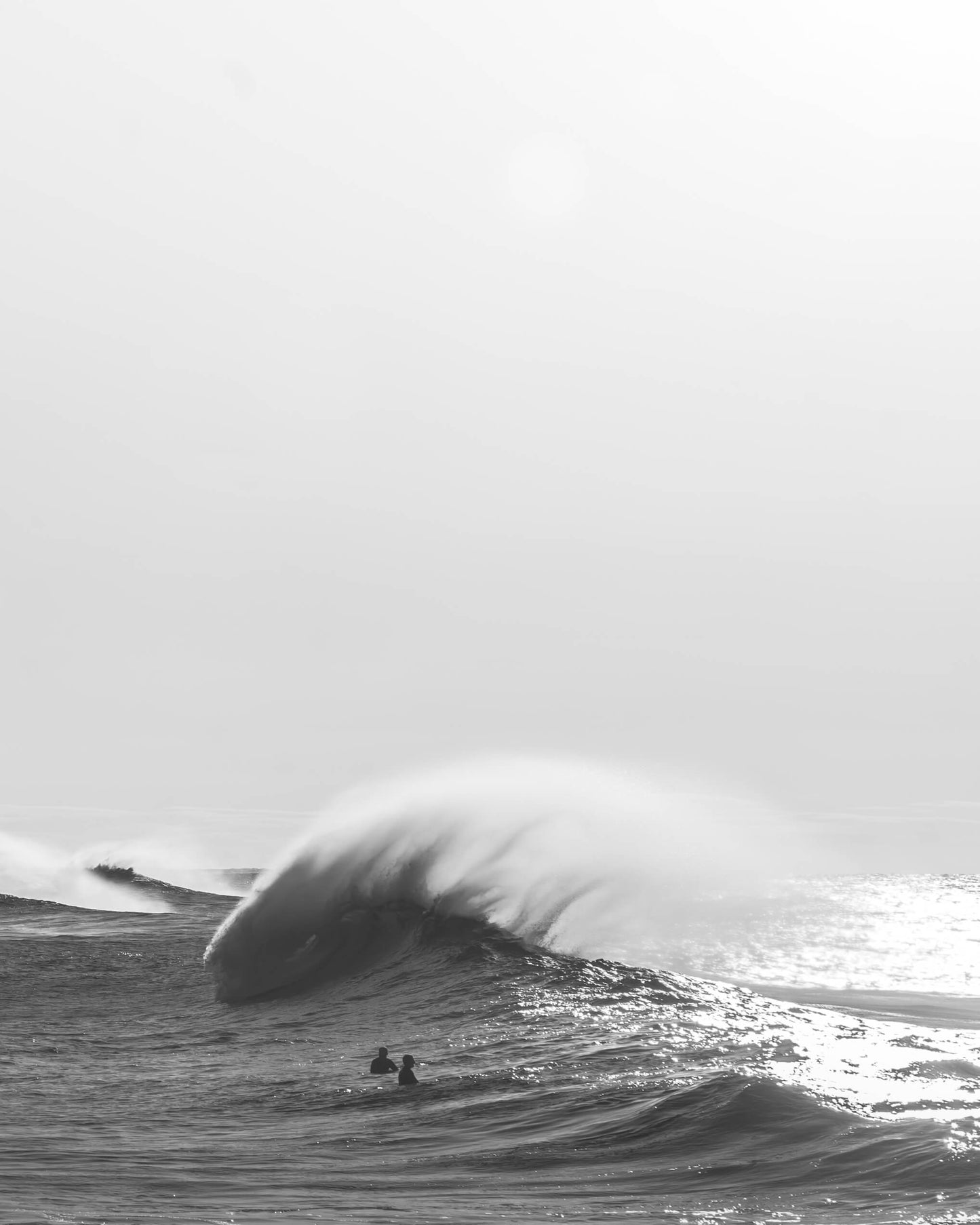Black and white photograph of two surfers and a large wave at Bronte Beach, Sydney, by Nicolas Letoublon