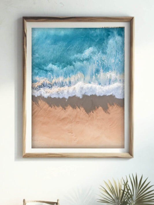 Framed aerial coastal photography print of a wave on the NSW coast displayed on a wall