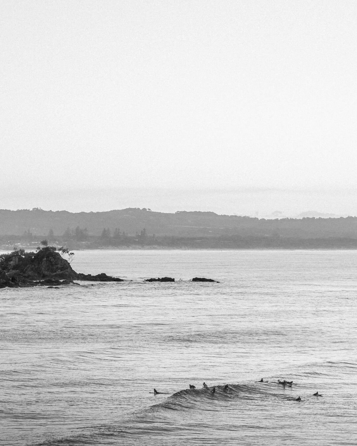 Black and white aerial photograph of a surfer at Wategos Beach, Byron Bay