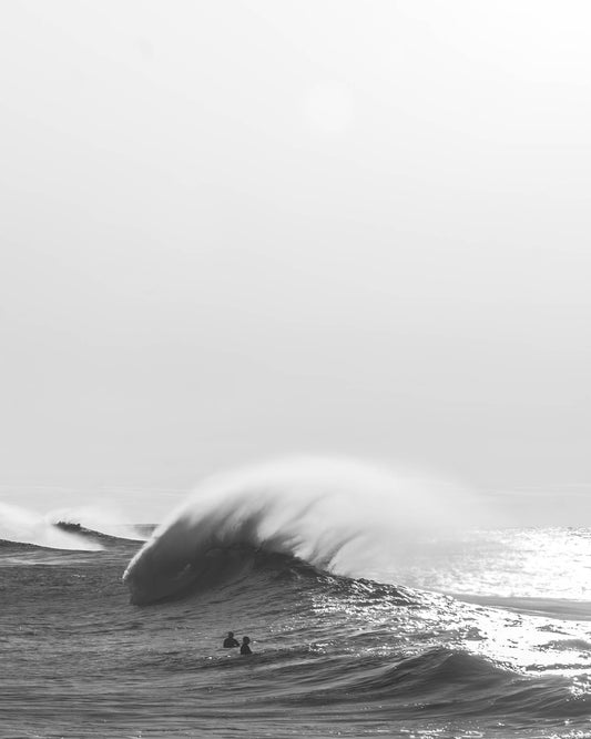 Black and white photograph of two surfers and a large wave at Bronte Beach, Sydney, by Nicolas Letoublon