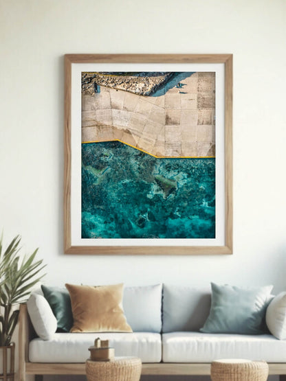 Framed aerial coastal photography print of Clovelly Beach Sydney on a wall