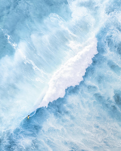 Aerial view of a surfer on a yellow board emerging from a barrel wave at Maroubra Beach, Sydney