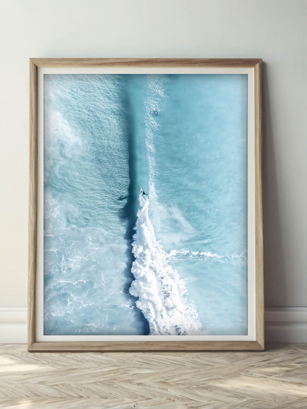 Framed aerial surf photography print of Byron Bay displayed on a wall