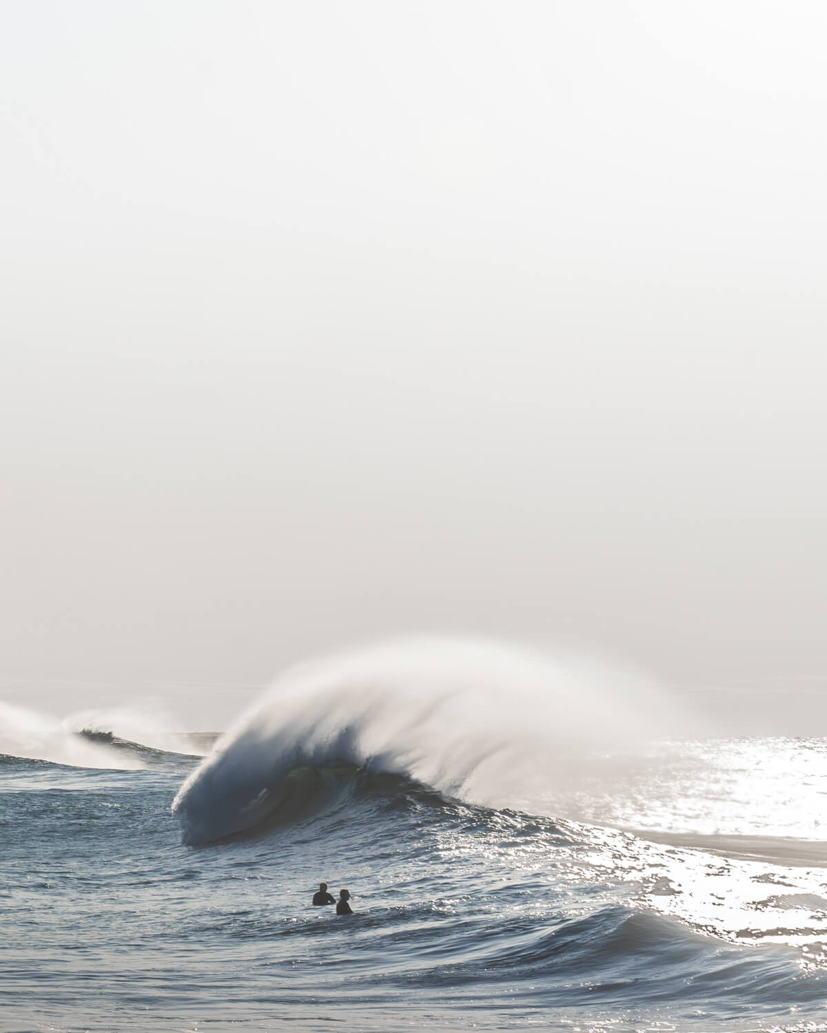 Ground-level view of a large powerful wave breaking at Bronte Beach, Sydney, with surfers waiting in the water