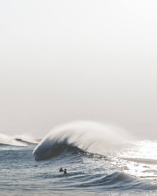 Ground-level view of a large powerful wave breaking at Bronte Beach, Sydney, with surfers waiting in the water
