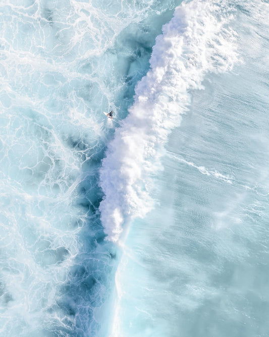 Aerial view of a surfer on a long diagonal wave at Maroubra Beach, Sydney