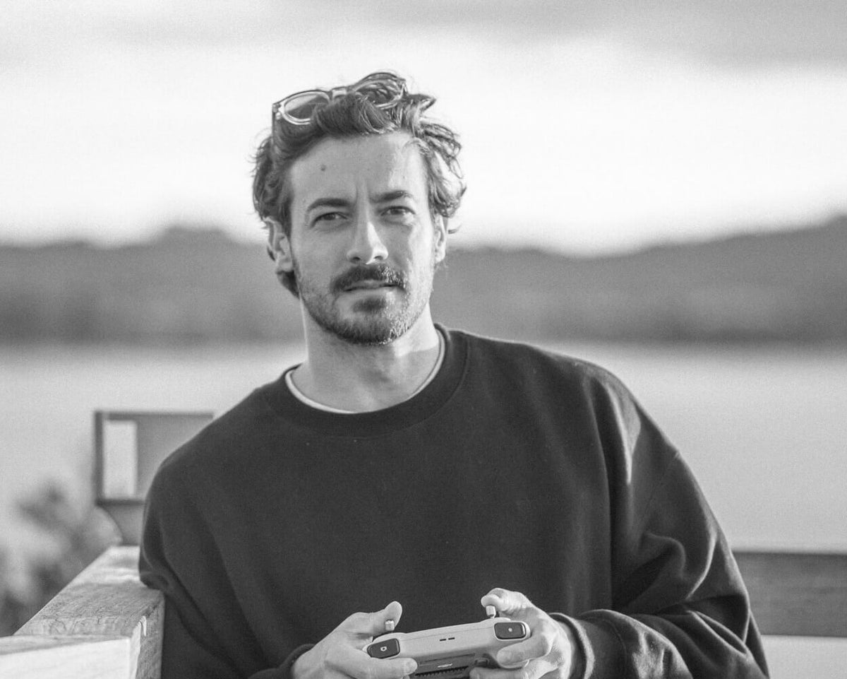 Portrait picture of the photographer Nicolas Letoublon holding his drone remote.