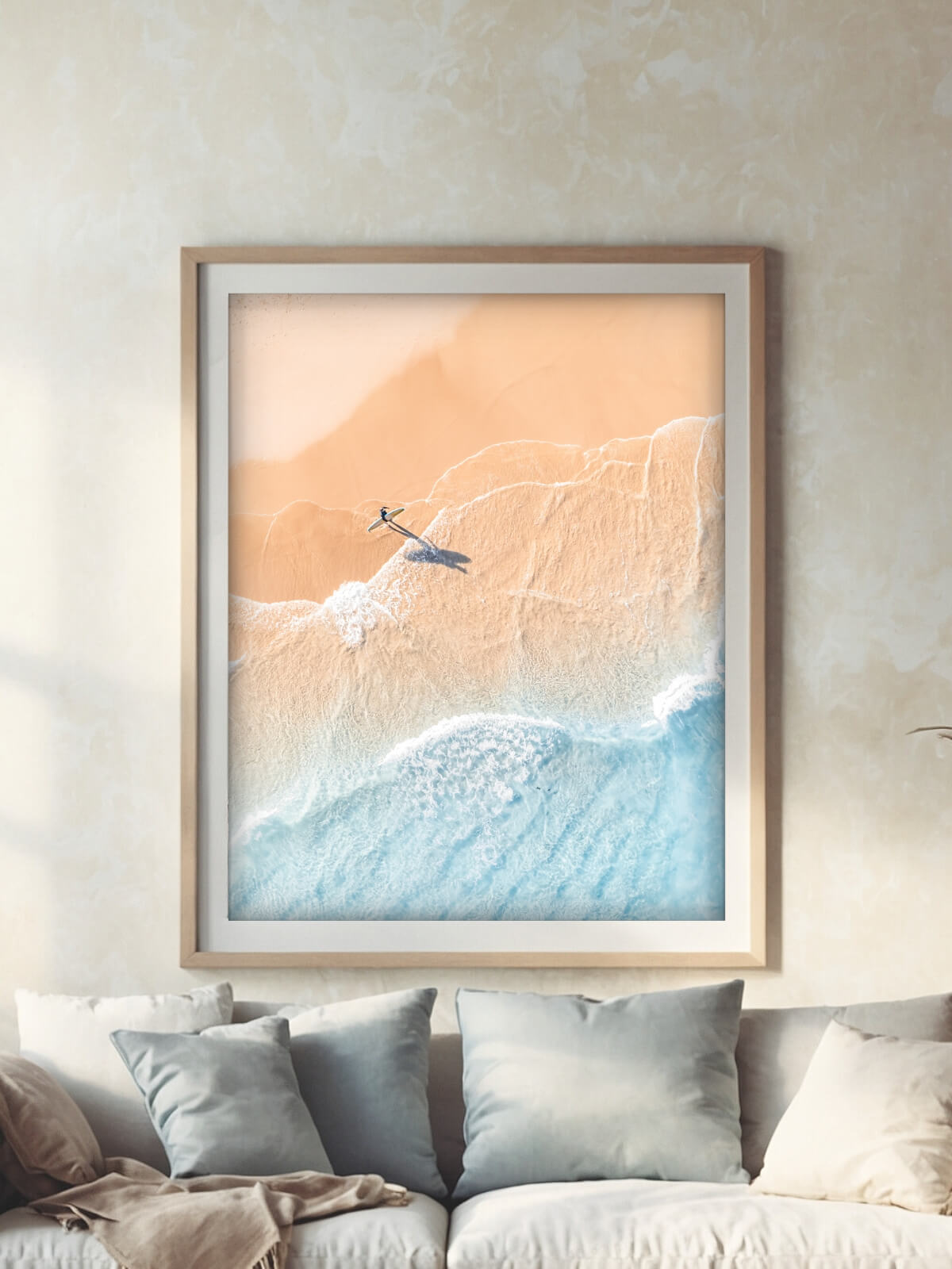 Framed aerial photography print of a lone surfer at The Pass Byron Bay on a wall