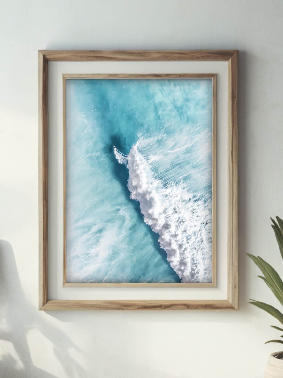 Framed aerial surf photography print of a surfer on a wave along the NSW coast on a wall