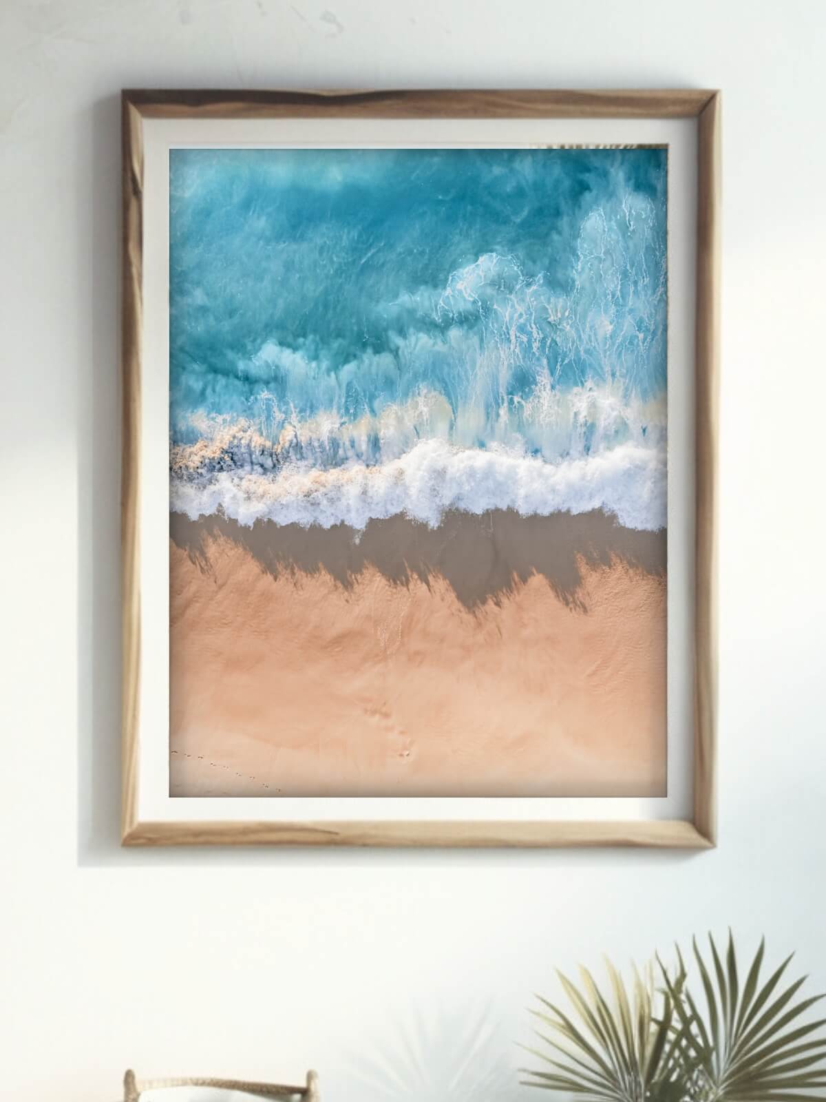 Framed aerial coastal photography print of a wave on the NSW coast displayed on a wall