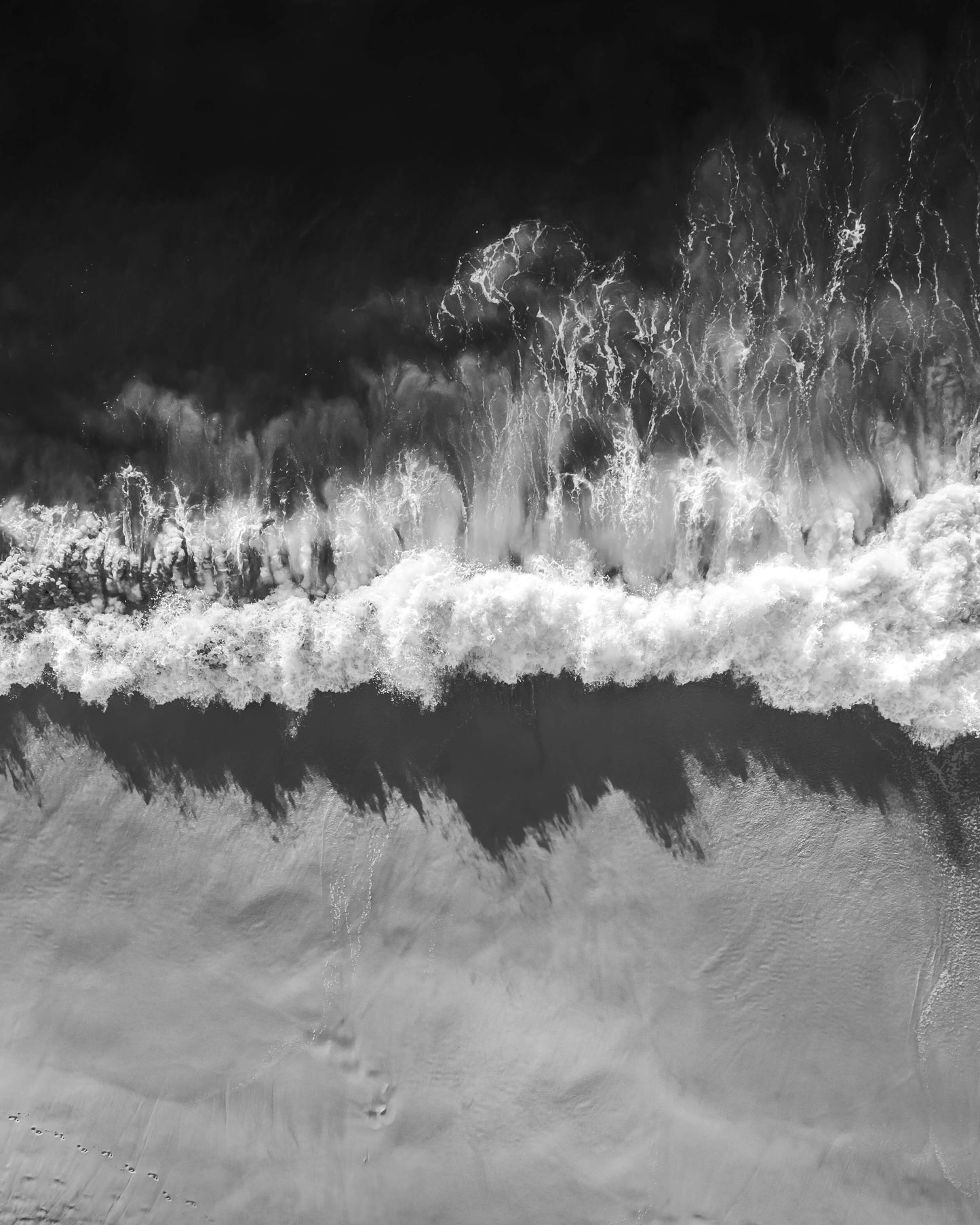 Aerial black and white photograph of a wave breaking on the shore at Bronte Beach, Sydney, by Nicolas Letoublon