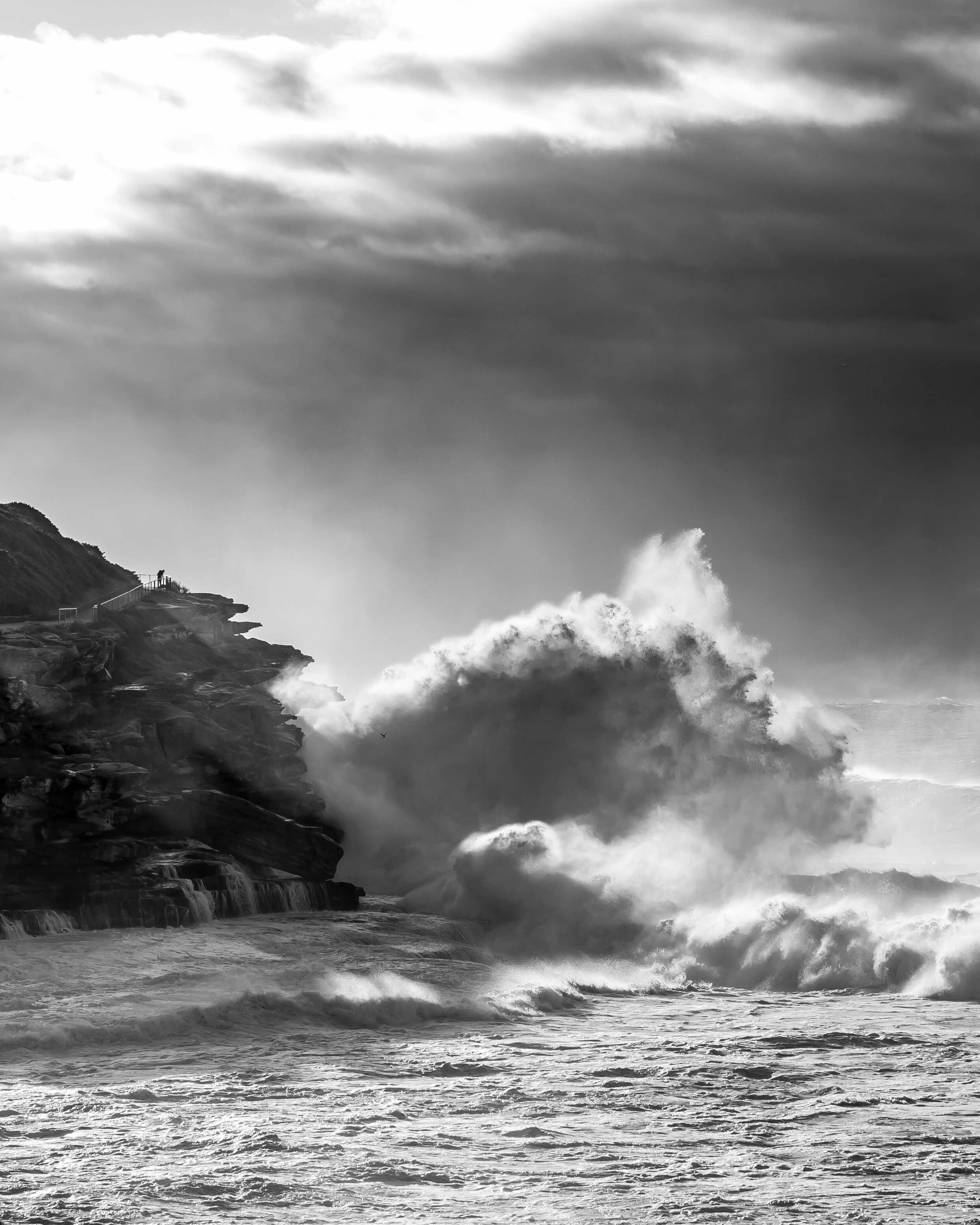 Black and white photograph of a large wave hitting the Tamarama headland, Sydney, by Nicolas Letoublon