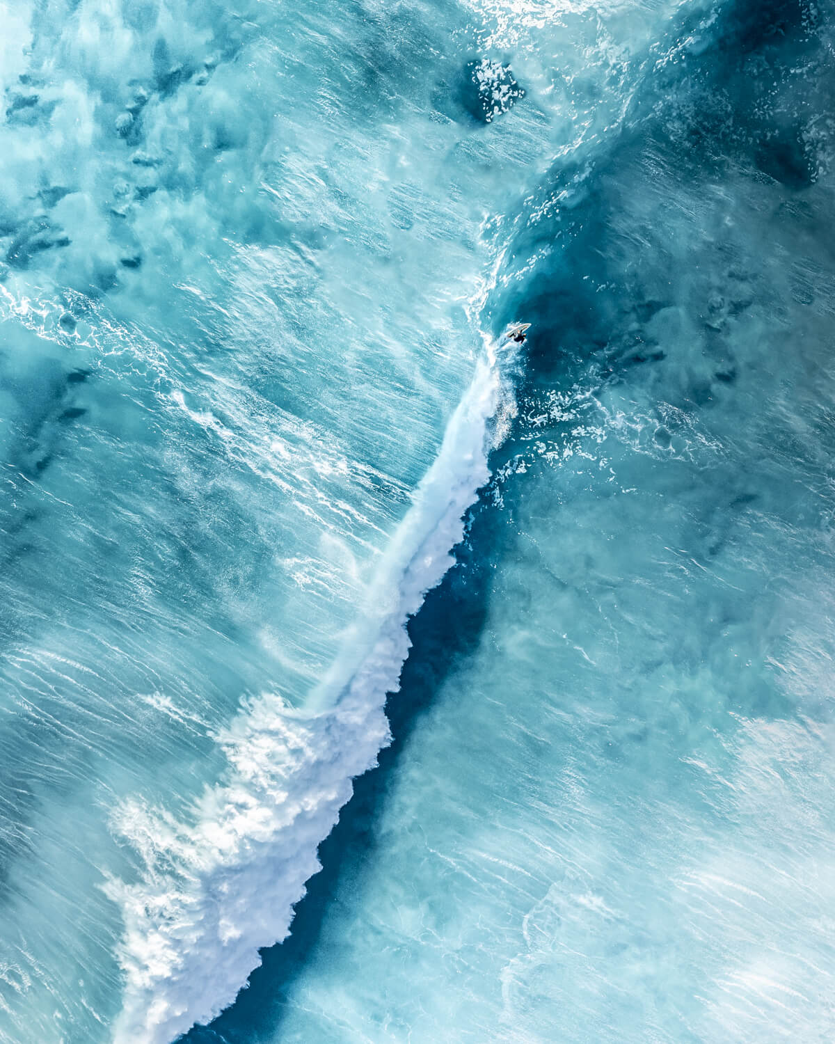 Aerial view of a surfer leaving a curved white wake at Bronte Beach, Sydney
