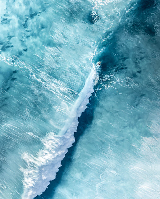 Aerial view of a surfer leaving a curved white wake at Bronte Beach, Sydney