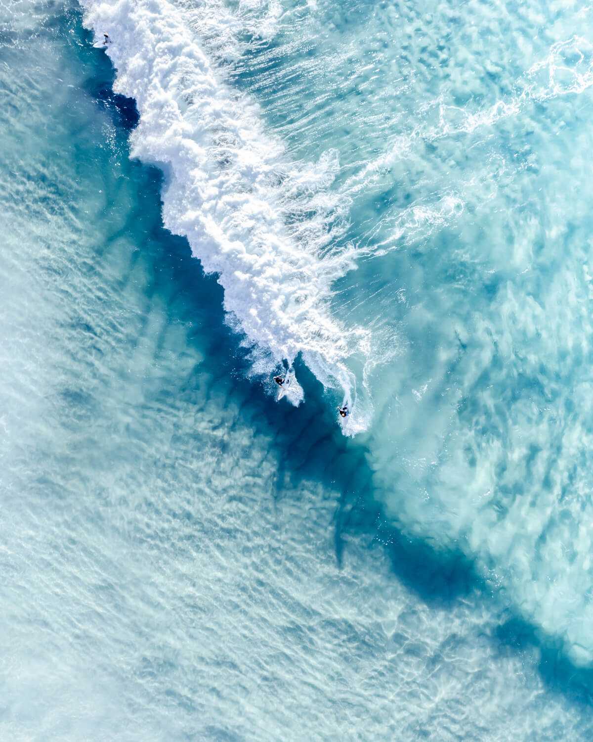 Aerial view of two surfers riding a wave in Bondi Beach, Sydney